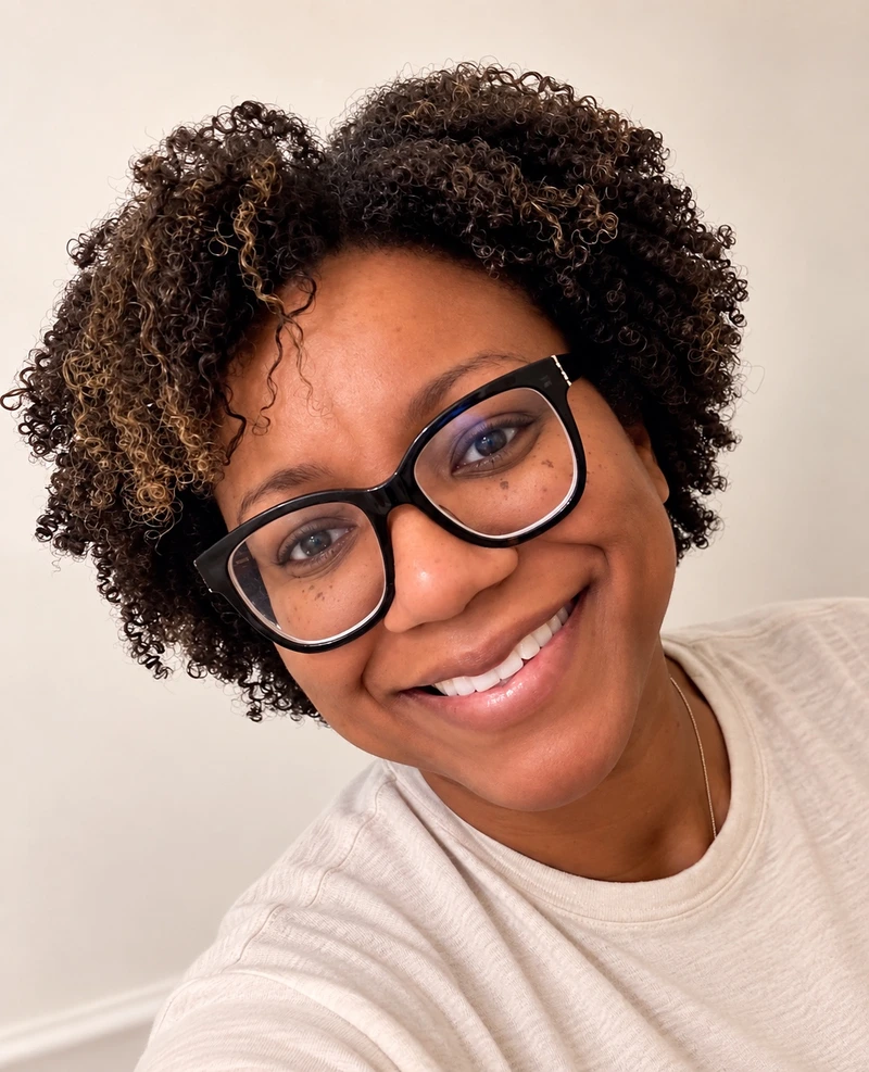 Shelly smiling in glasses and a cream top.